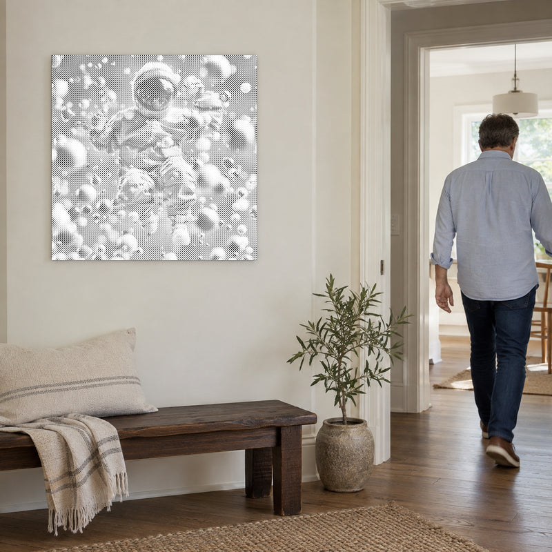 Stippenschilderij “Abstracte Astronaut”, aan een lichte muur, met iemand die door de deur ernaast loopt.