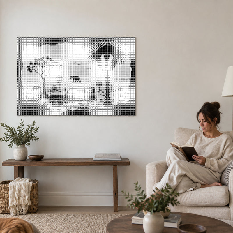 Stippenschilderij “Avontuur in de wildernis”, aan een muur in de woonkamer, met iemand die ernaast in een fauteuil leest.