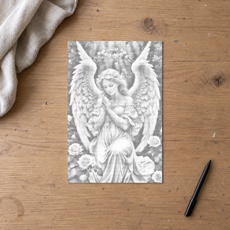 Stippenschilderij “Engel met delicate rozen”, op een eiken werktafel naast een zwarte marker.