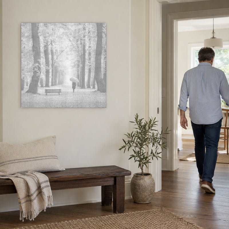 Stippenschilderij “Herfstbos”, aan een lichte muur, met iemand die door de deur ernaast loopt.