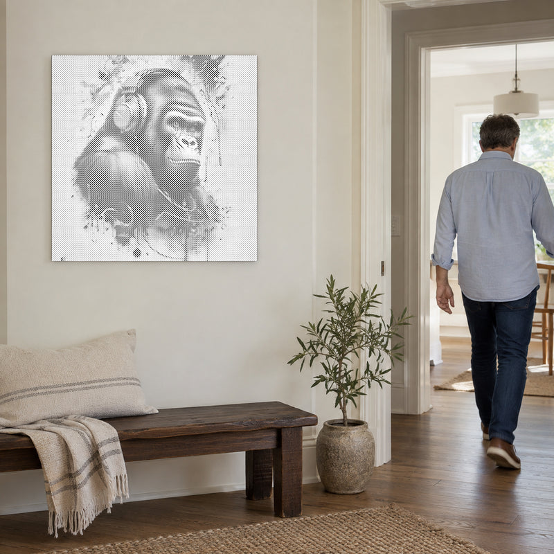 Stippenschilderij “Gorilla met Hoofdtelefoon”, aan een lichte muur, met iemand die door de deur ernaast loopt.