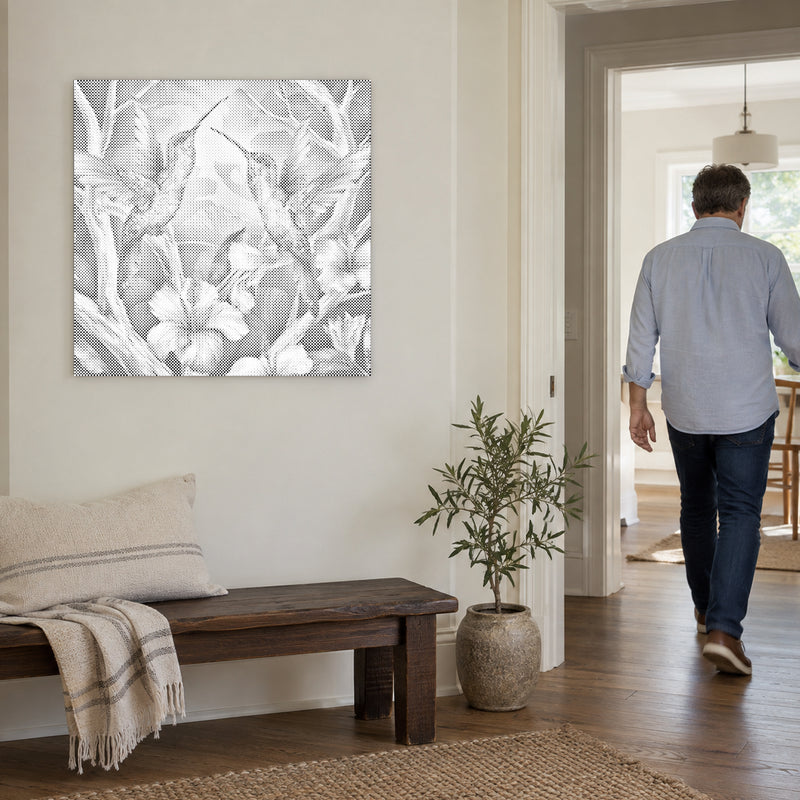 Stippenschilderij “Kolibries tussen bloemen”, aan een lichte muur, met iemand die door de deur ernaast loopt.