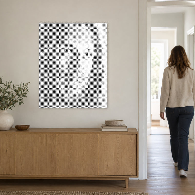 Stippenschilderij “Jezus Christus”, aan een lichte muur, met iemand die door de deur ernaast loopt.