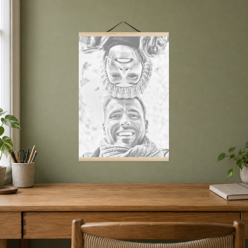 Magnetische lijst voor stippelschilderijen, aan een zachte olijfgroene muur boven een eiken bureau.