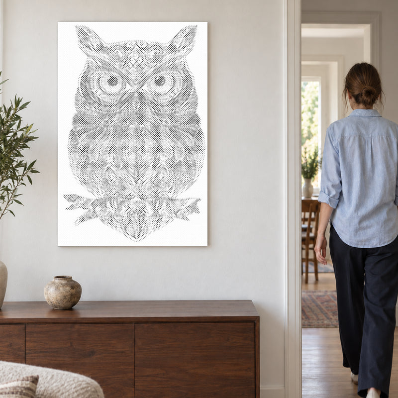 Stippenschilderij “Uilen Mandala”, aan een lichte muur, met iemand die door de deur ernaast loopt.
